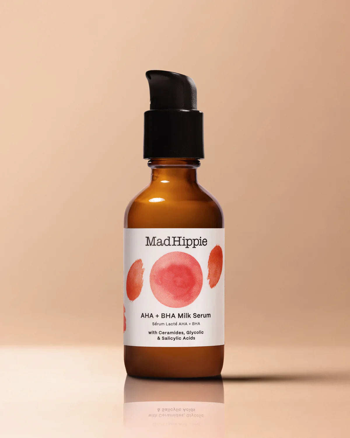 Brown bottle with black pump, labeled "Mad Hippie AHA + BHA Milk Serum" on beige background.