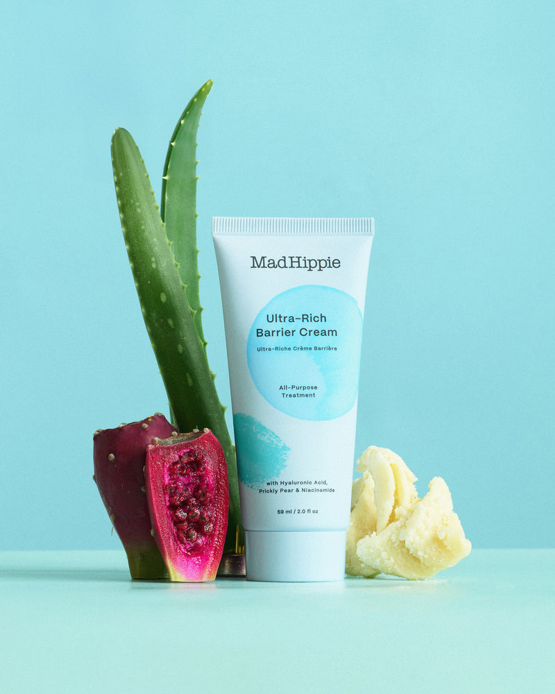 Cream tube with aloe, prickly pear, and shea butter on a light blue background.